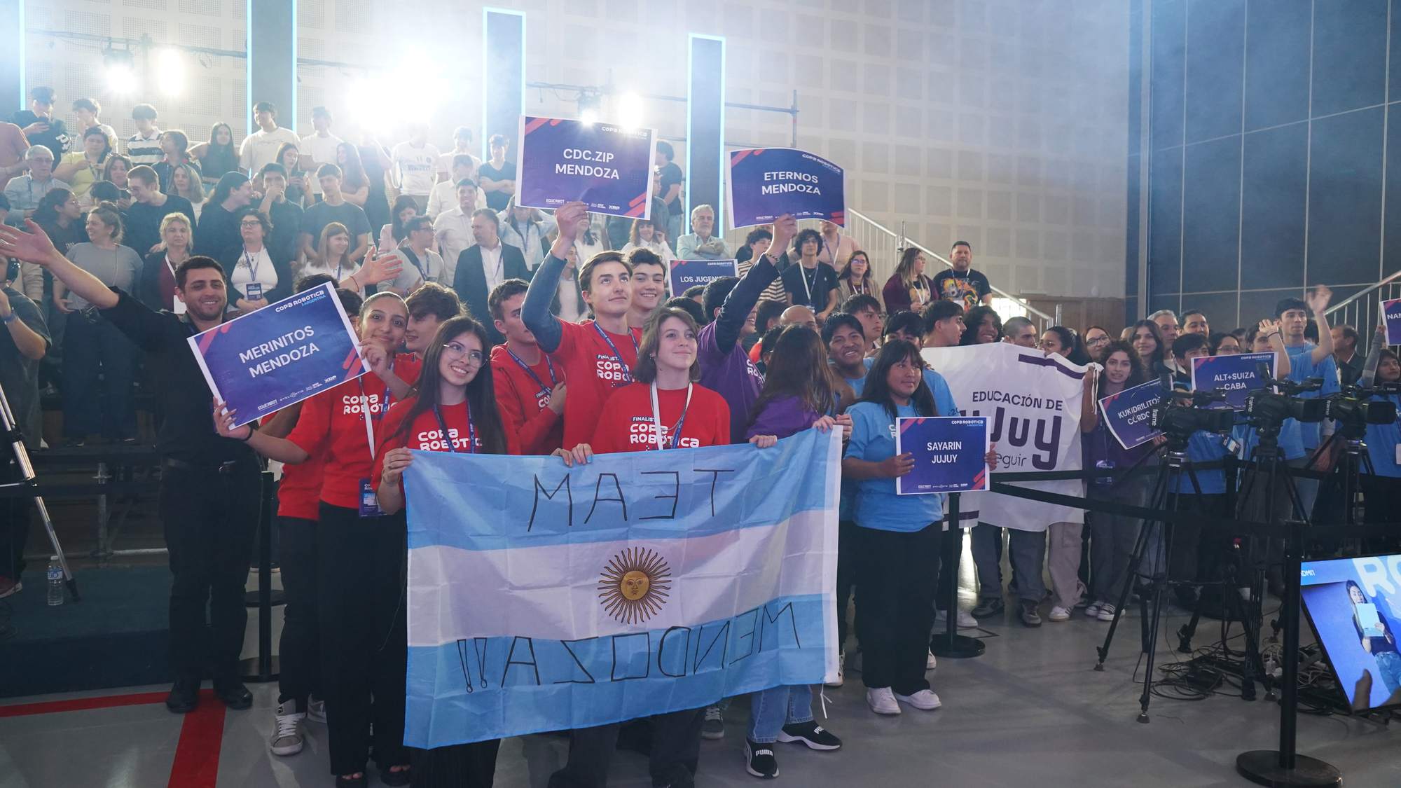 Equipos finalistas de Mendoza, Jujuy y CABA con sus carteles y la bandera argentina en la Final Nacional