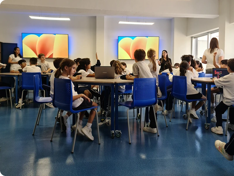 Estudiantes trabajando en el aula con notebooks